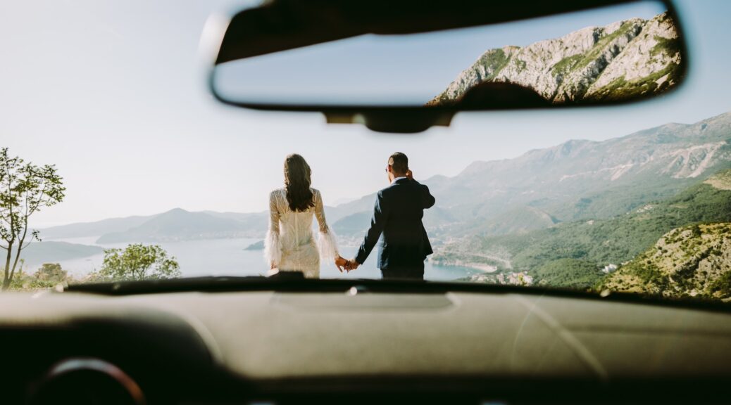 honeymoon couple travel by car in mountains