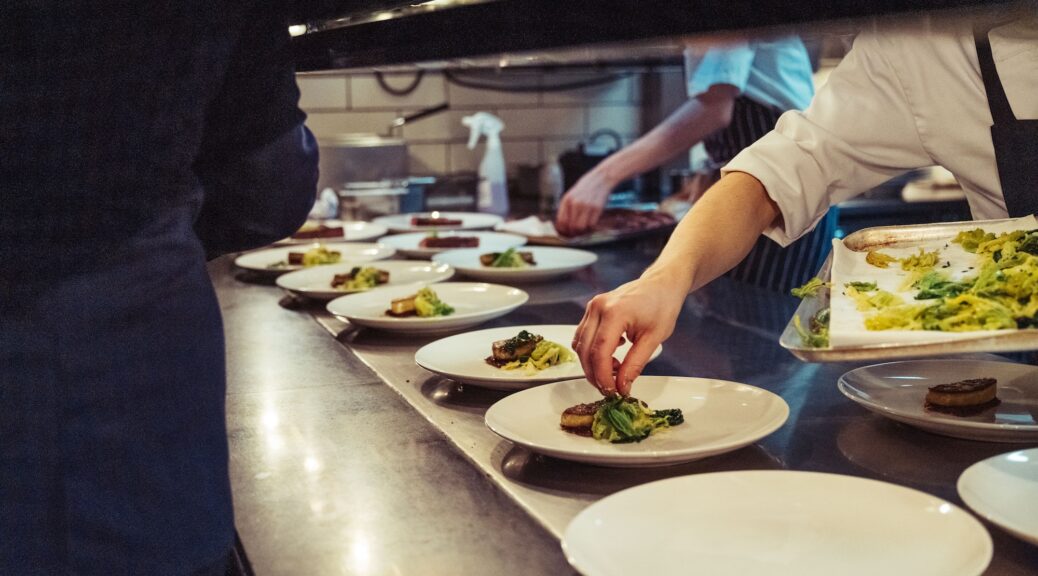 Closeup shot of the chefs preparing a fine dinner at the kitchen in a restaurant in London, England